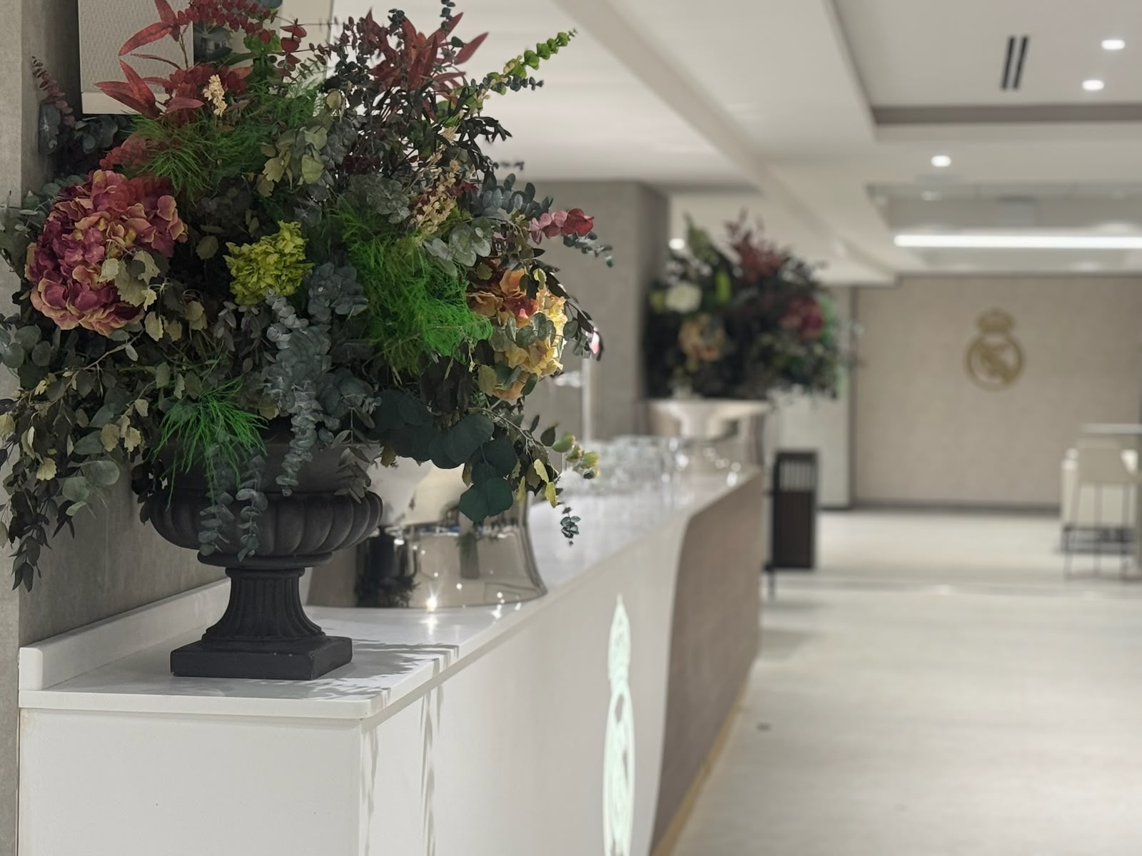 Gran centro floral otoñal en urna sobre una barra de recepción